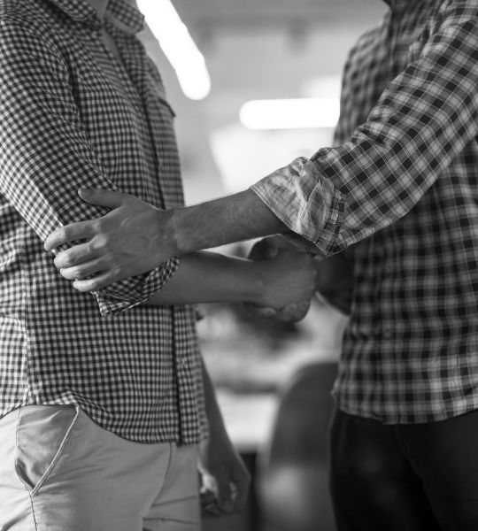 Two people coming together for a partnership and shaking hands. Likely the private intelligence contractors at Reveille Advisors and one of their clients.