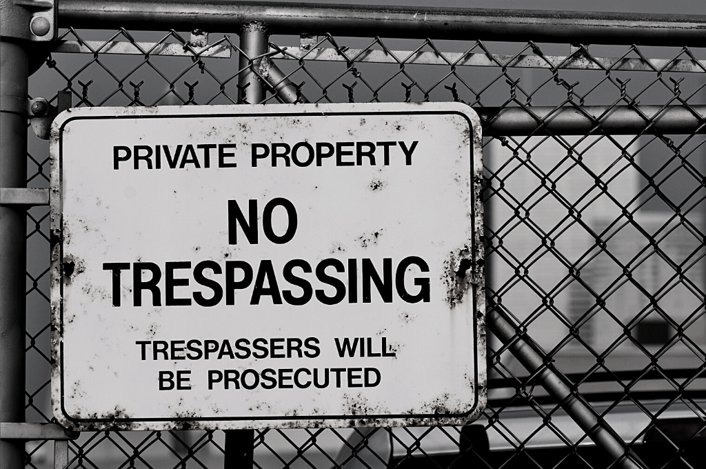 A No Trespassing sign on a chain link fence outside of some sort of facility. Reveille Advisors and our expert threat prevention specialists will play the "bad guys" and identify all your weaknesses.