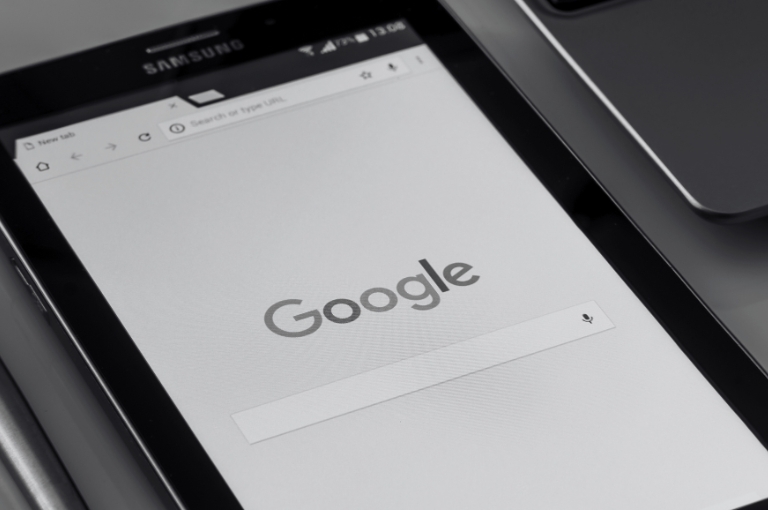 A Samsung smartphone showing Google's Search homescreen. Reveille offers SEO services that improve brand authority, visibility, and revenue.